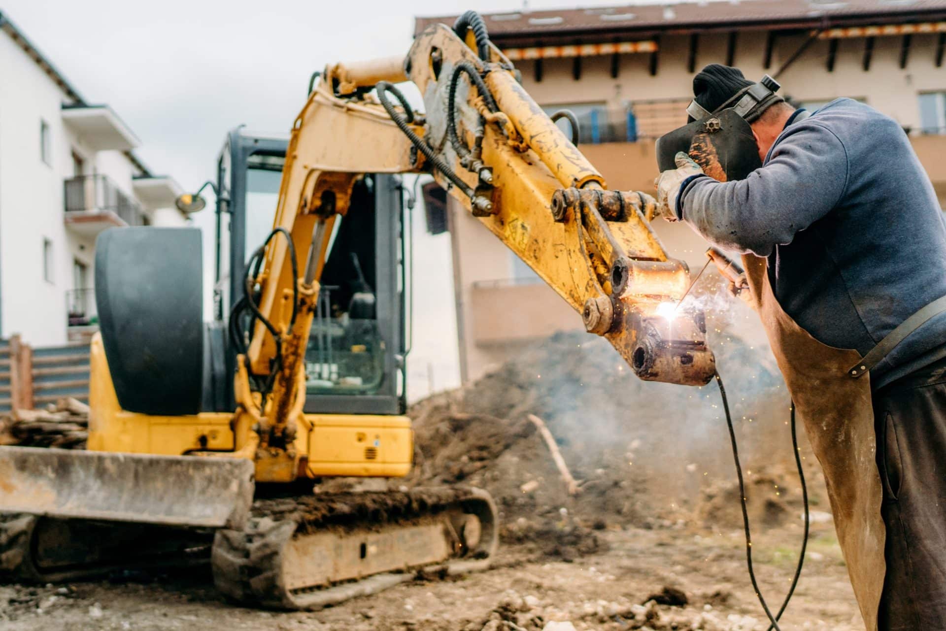 construction-and-building-site-broken-excavator-and-professional-welder-e1600416999476